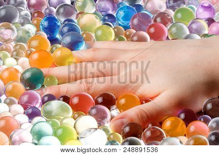 Hand Hanging In The Balls Of The Hydrogel, Among The Hydrogel Multi-colored Balls