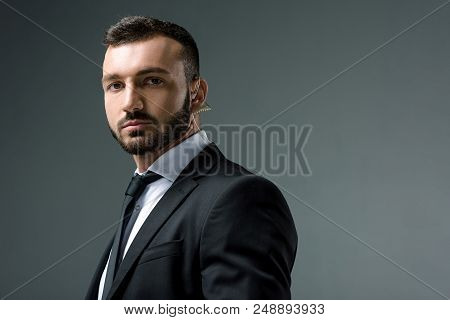 Handsome Security Guard With Security Earpiece Looking At Camera Isolated On Grey