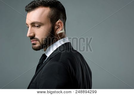 Side View Of Handsome Security Guard With Security Earpiece Isolated On Grey