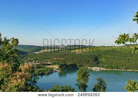 View From The Hill To The Slopes Of The Caucasus Mountains Around The Picturesque Lake Abrau. Sunny