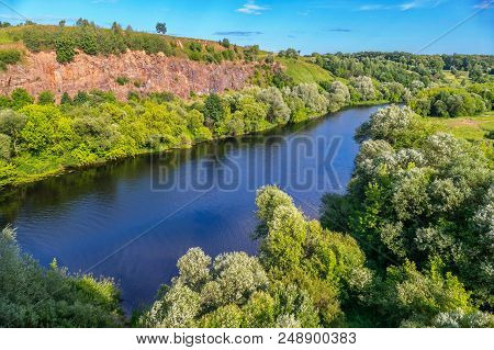 River Bay With Clear Blue Water On A Background Of Rocky Mountain And Green Plantations