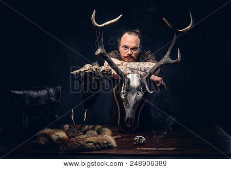 Pensive Redhead Taxidermist Hipster Male In Sunglasses Dressed In A Brown Shirt, Standing Near A Tab