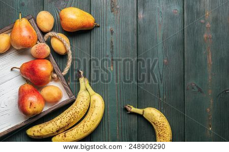 Fresh Fruit On A White Wooden Tray: Banatas, Pears, Apricots. Countryside Setting. Top View. Copy Sp