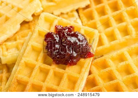 Close-up Of Homemade Fresh Brown Waffles.
View To Stacked Wafles With Tasty Jam.
Bakery And Food Bac