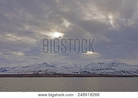 Sun Trying To Break Through On Coastal Mountains In The Vaigat Channel In West Greenland