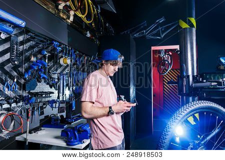 A Young, Stylish Redheaded Male Small Business Owner Selling And Repairing A Bike Is Wearing A Blue 