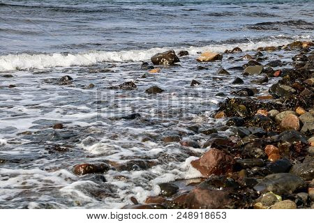 Incoming Tide Breaking On A Rocky Coastal Beach