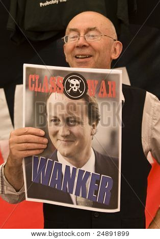 Attivista di guerra di classe regge un poster sul primo ministro britannico David Cameron