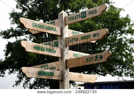 Wooden Sign In A Showground With Twelve Arms Pointing The Way To Various Attractions And Facilities