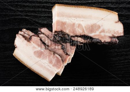 Group Of Three Slices One Piece Of English Bacon Flatlay On Black Wood