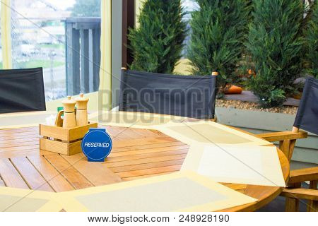 Leisure, People And Service Concept - Restaurant Table Setting Service For Reception With Reserved C