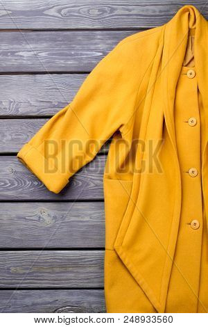 Warm Winter Coat. Rolled Sleeve. Grey Wooden Surface Background. Flat Lay, Top View.