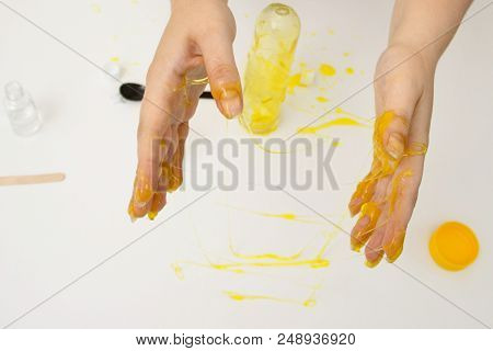 How To Make Slime. A Female Hands Holds Yellow Homemade Slime Is A Children's Toy Close Up. Composit