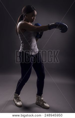 Black Female Wearing Boxing Gloves Training Or Exercising.  She Is Posing With Punches And Depicts F