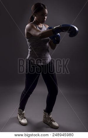 Black Female Wearing Boxing Gloves Training Or Exercising.  She Is Posing With Punches And Depicts F