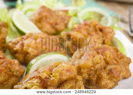 Close Up View Of Favourite Indian Appetizer, Indian Bhajias Or Bhajis, On A White Plate With Sliced 
