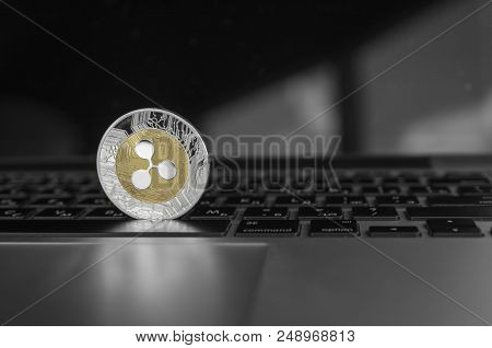 Silver Gold Ripple Coin On A Laptop Keyboard Closeup. Blockchain Mining. Digital Money And Virtual C