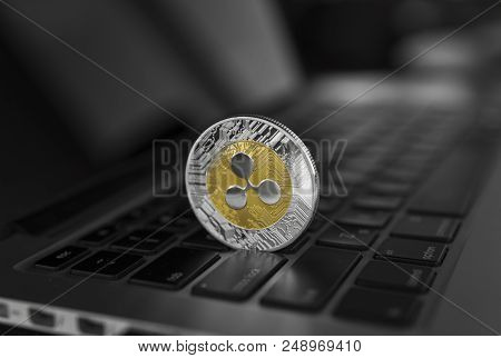Silver Gold Ripple Coin On A Laptop Keyboard Closeup. Blockchain Mining. Digital Money And Virtual C