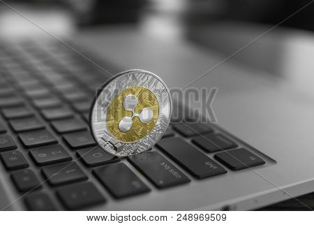 Silver Gold Ripple Coin On A Laptop Keyboard Closeup. Blockchain Mining. Digital Money And Virtual C