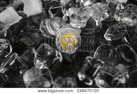 Gold Ripple Coin On Ice Background. The Concept Of The Exchange In Winter. Freeze. Blockchain Mining