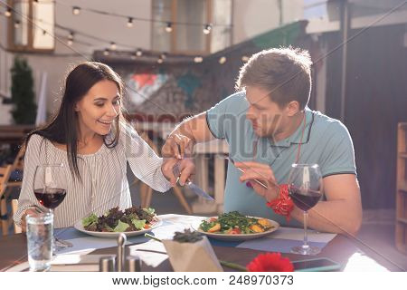 Avaricious Man. Blonde-haired Man Feeling Avaricious While His Woman Trying His Food