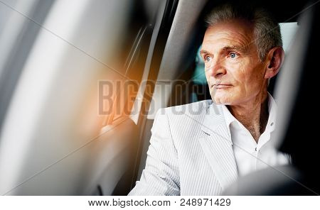 Old Bussines Man Sitting In The Car And Look Around. Thinking About New Possibilities.