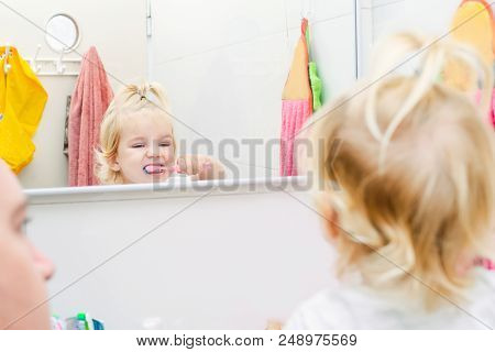 Close Up Father And Little Toddler Daughter Brushing Her Teeth And Looking In The Mirror In The Bath