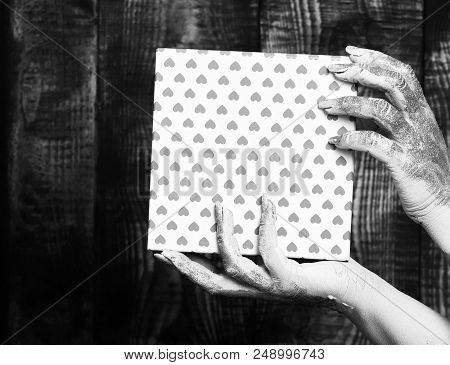 Female Hands Smeared In Golden Paint Or Glister Holding Pink Polka Dots Valentine Present Box On Bro