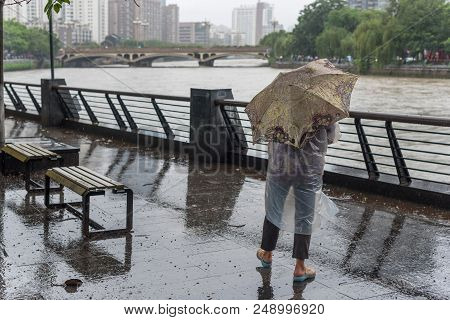 Chengdu, Sichuan Province, China - July 11, 2018 : Man With An Umbrella Watching Jinjiang River In F