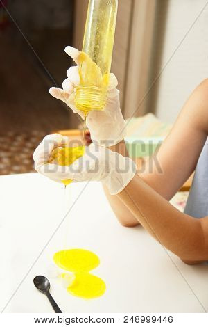 Young Beautiful Girl Shows How To Make Slime. Yellow Homemade Slime Is A Children's Toy. Composition