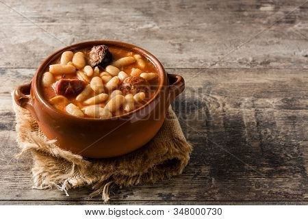 Typical Spanish Fabada Asturiana On Wooden Table. Copy Space