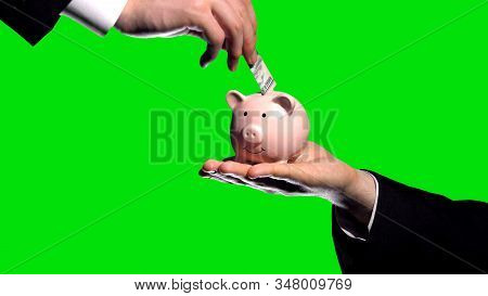 Investor Puts Money In Partners Piggybank Green Screen Background, Financial Aid