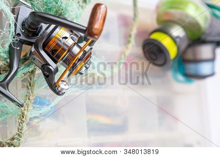 Different Fishing Tackles, Lines And Reel On Wooden Cork Background.