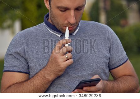 Electronic Cigarettes, Cigarette Technology. Tobacco Iqos System. Close-up Of A Man Smoking An Elect