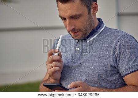Electronic Cigarettes, Cigarette Technology. Tobacco Iqos System. Close-up Of A Man Smoking An Elect