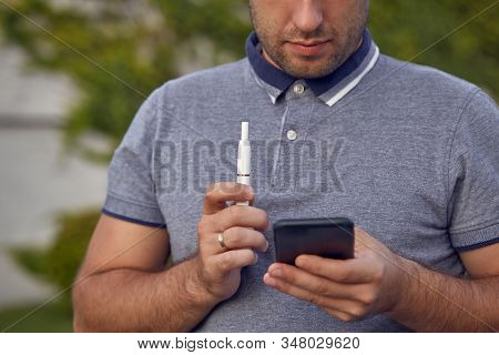 Electronic Cigarettes, Cigarette Technology. Tobacco Iqos System. Close-up Of A Man Smoking An Elect