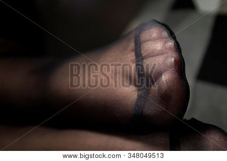 A Portrait Of The Feet Of A Girl In Black Pantyhose With The Nylon At The Toes Being Reinforced.