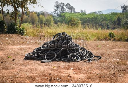 Old Tires On The Grass / Industrial Landfill For The Processing Of Waste Tires And Rubber Tyres Pile