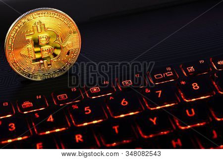 Gold Bitcoin On The Red Keyboard Notebook. A Visual Representation Of Digital Cryptocurrencies. Bitc