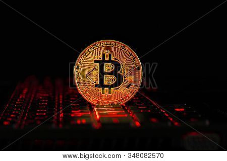 Gold Bitcoin On The Red Keyboard Notebook. A Visual Representation Of Digital Cryptocurrencies. Bitc