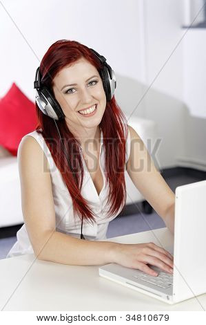 Mujer con auriculares trabajando en Laptop