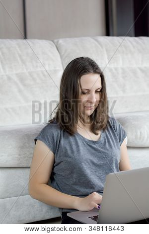 Young Beautiful Woman At Home Sitting On The Floor With Laptop.