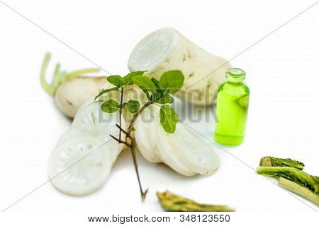 Freshly Sliced Daikon Radish Along With Its Extracted Essence In A Small Glass Bottle.