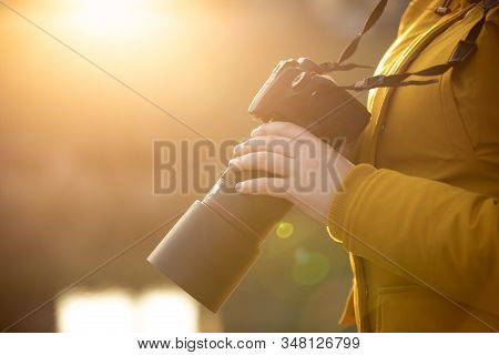 Young Woman Photographer With Professional Camer In Hand During Sunset