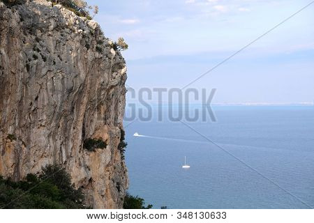 High Impregnable Plateau With Mountain Vegetation On Top And Calm Sea Far And Down On Skyline On Sun