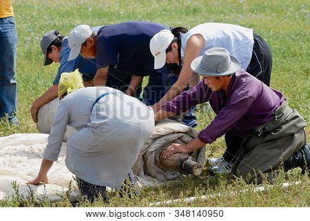 Harhorin, Mongolia - August 20, 2006: Mongolian People Roll Felt In Steppe In Harhorin, Mongolia. Fe