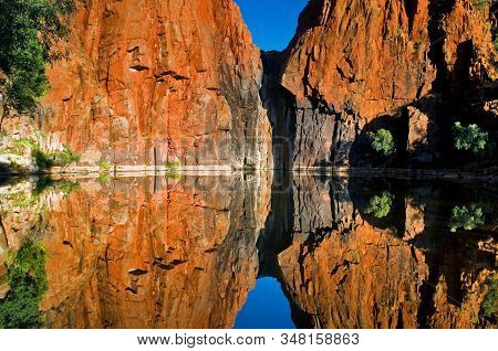 Red Rock Face Reflecting In Python Pool