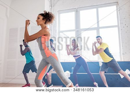 Selective Focus Of African American Trainer Practising Movements With Multiethnic Zumba Dancers In D