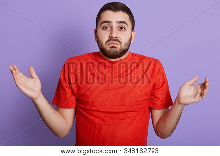 Close Up Portrait Of Helpless Young Handsome Man Raising Hands, Being Disappoined, Wearing Red Casua