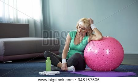 Tired Middle Aged Female Relaxing On Yoga Mat After Active Home Workout, Dyspnea